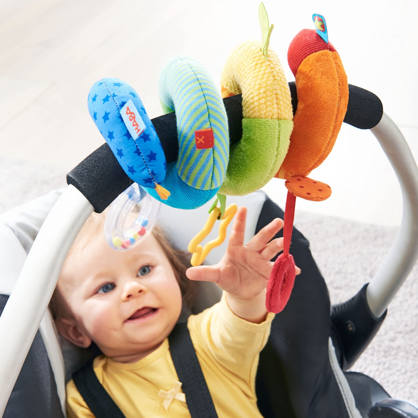 HABA Rainbow Activity Spiral Car Seat Toy and Stroller Toys for Baby 0-18 Months - Colorful Baby Travel Toy with Rattle Teething Element and Sensory Activities